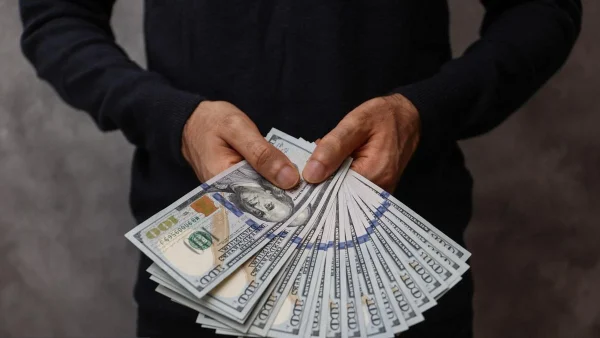یک درسته دلار در دست یک مرد