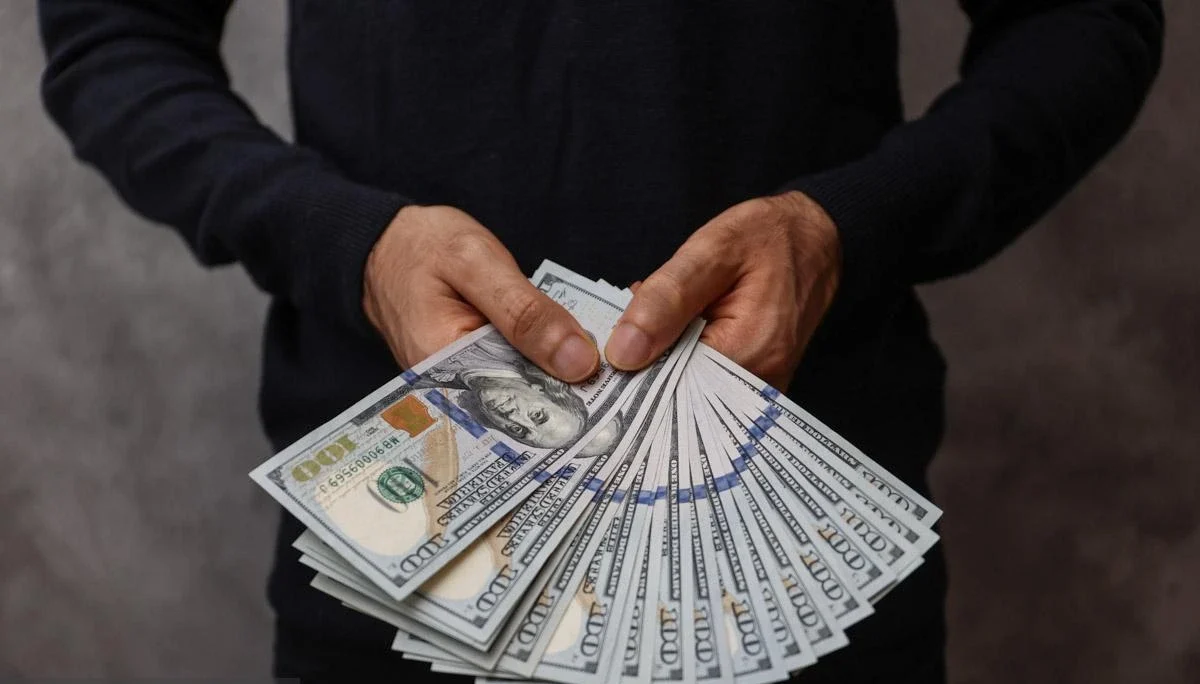 یک درسته دلار در دست یک مرد